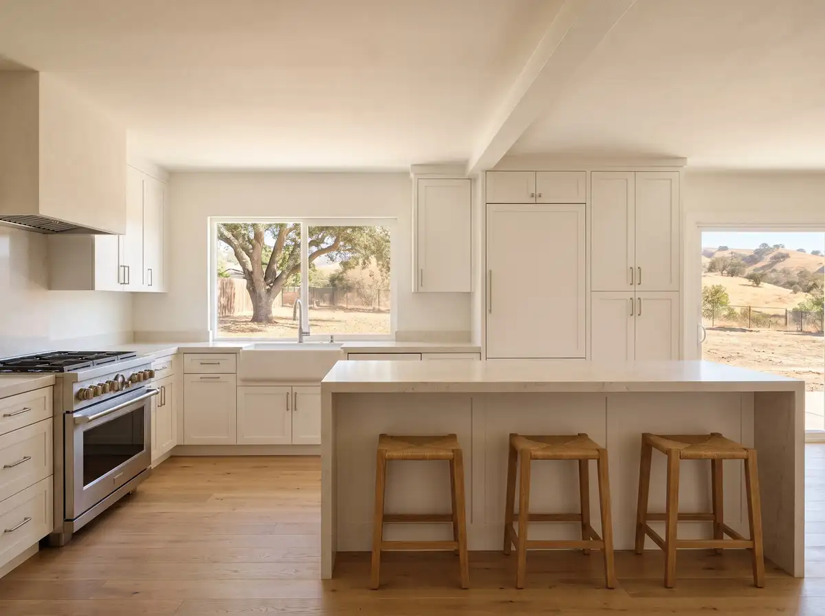 Open kitchen with a long quartz island and white shaker cabinets where a wall used to stand, AI-generated illustration